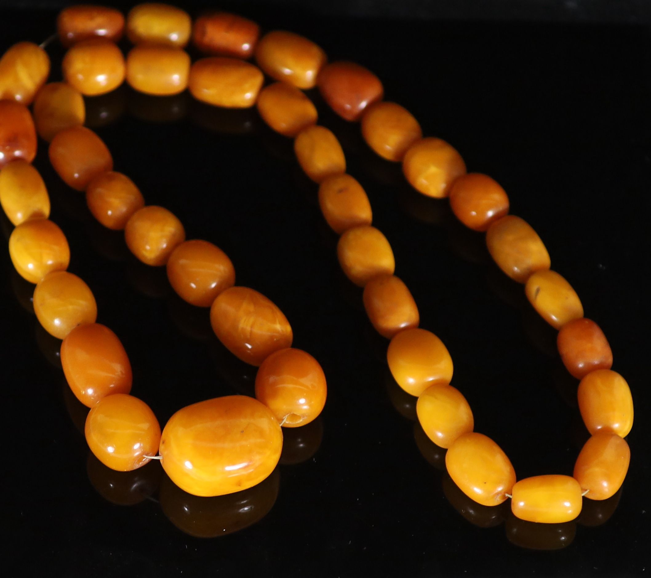 A single strand graduated oval amber bead necklace, 84cm, gross weight 182 grams,